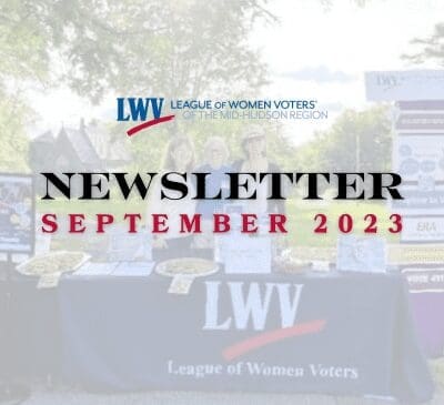 Table with informational materials and banners promoting the League of Women Voters of the Mid-Hudson Region. Newsletter for September 2023.