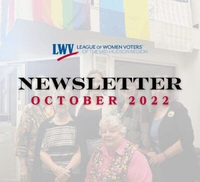 A group of people posing indoors. A banner with "League of Women Voters of the Mid-Hudson Region" is visible. Text reads "Newsletter October 2022." Flags hang in the background.