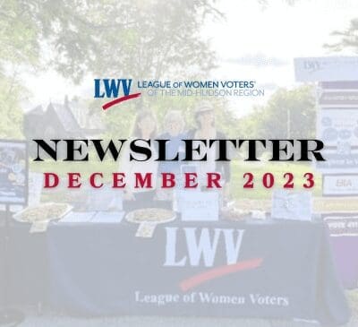 Cover of the League of Women Voters of the Mid-Hudson Region newsletter for December 2023, featuring a table with flyers and informational materials.