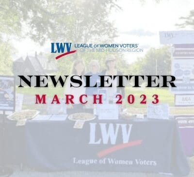 A booth with "League of Women Voters of the Mid-Hudson Region" branding at an outdoor event, featuring promotional items and informational boards. Text overlay reads "Newsletter March 2023.